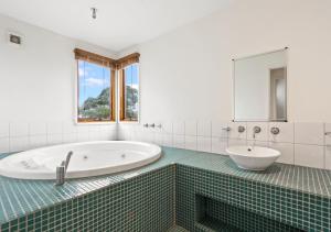 Un baño blanco con bañera y lavabo. en Piz Gloria, en Dinner Plain 14 fotos más