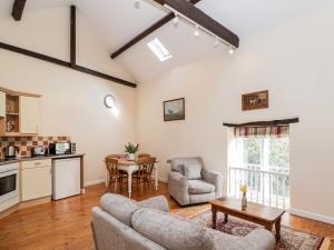 una sala de estar con un sofá y una mesa en The Old School Room, en Chelborough