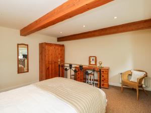 a bedroom with a bed and a mirror and a chair at The Old School Room in Chelborough