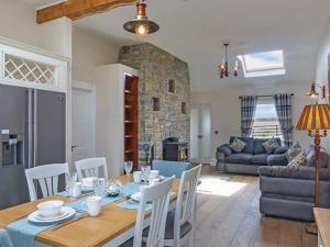 a dining room and living room with a table and chairs at Farmhouse in Lisdoonvarna