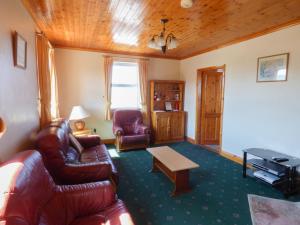a living room with a couch and chairs and a table at Seaview Cottage in Ballyvaughan
