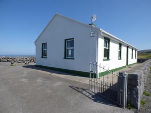 a white building with a fence in front of it at Seaview Cottage in Ballyvaughan
