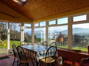 a dining room with a table and chairs and windows at Sugarbush in Eyeries