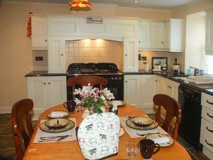 a kitchen with a table with plates and flowers on it at Nellie's Farmhouse in Bantry