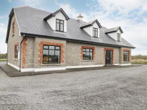 uma grande casa de tijolos com uma entrada em Cloonacastle Cottage em Ballinrobe