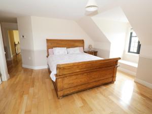 een slaapkamer met een bed en een houten vloer bij Cloonacastle Cottage in Ballinrobe