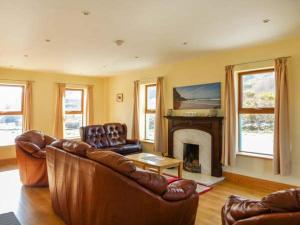 a living room with a couch and a fireplace at 6 Strand Cottages in Doogort