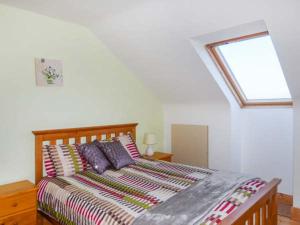 una camera da letto con un grande letto e una finestra di 6 Strand Cottages a Doogort