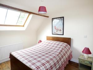 a bedroom with a bed with a plaid blanket at Berrylane in Enniscorthy
