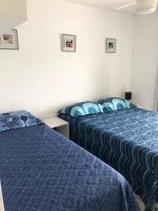 two beds in a hotel room with blue comforter at Ilha da Madeira Resort - Cobertura com Jacuzzi in Riviera de São Lourenço +37 photos