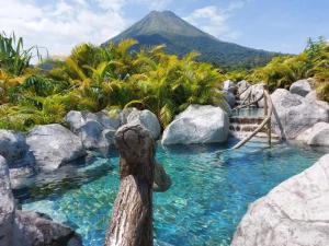 a pool of water with a mountain in the background at Relax Termalitas and Hot Springs in Fortuna
