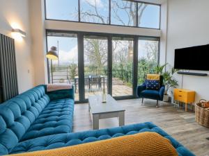 a living room with a blue couch and a table at The Hay Barn in Houghton le Spring