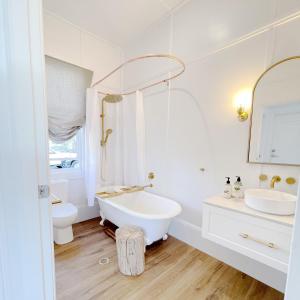 a white bathroom with a tub and a toilet at Waukivory Estate - The Cottage 