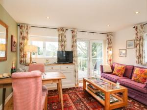 a living room with a couch and a table at Little Retreat in Upwey