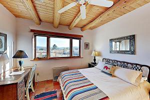 a bedroom with a bed and a desk and a window at Casa Allis Taos in El Prado