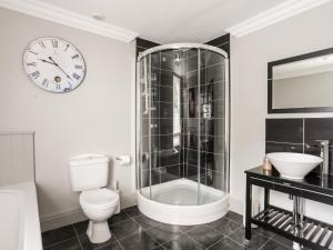 a bathroom with a toilet and a clock on the wall at Maelgwyn in Criccieth +33 photos