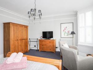 a bedroom with a bed and a tv and a dresser at Maelgwyn in Criccieth