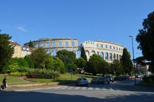 a large white building with cars parked on a street at Apartment Rosy in Pula