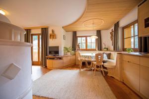 uma cozinha com uma mesa e uma sala de jantar em Chalet Prinoth em Selva di Val Gardena