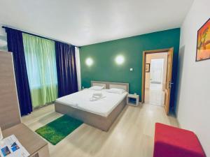 ブカレストにあるCentral Unirii - Old Town Apartmentsの緑の壁、ベッド付きのベッドルーム1室