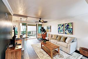 uma sala de estar com um sofá e uma mesa em Hale Ono Loa 210 em Kahana