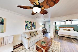 a living room with a couch and a ceiling fan at Hale Ono Loa 210 in Kahana