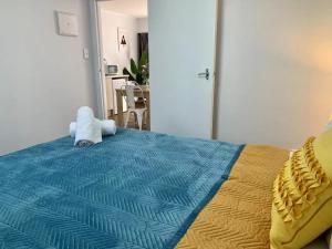 - une chambre dotée d'un lit avec une couverture bleue et jaune dans l'établissement Auckland Central Motel, à Auckland