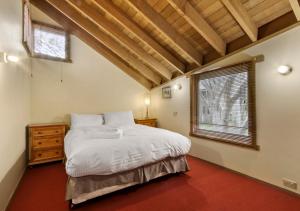 a bedroom with a large bed and a window at Seadog in Dinner Plain