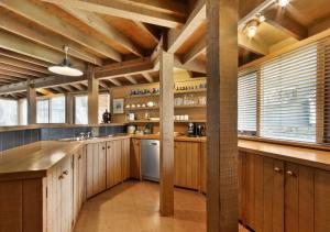 a large kitchen with wooden cabinets and wooden beams at Seadog in Dinner Plain