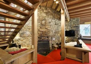 a living room with a fireplace and a stone wall at Seadog in Dinner Plain