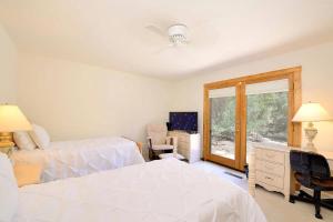 1 Schlafzimmer mit 2 Betten, einem TV und einem Fenster in der Unterkunft Santa Fe Manor in Santa Fe