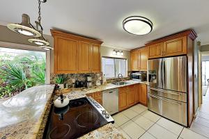a kitchen with wooden cabinets and stainless steel appliances at Kuapa Isle Gem Unit 419 in Honolulu