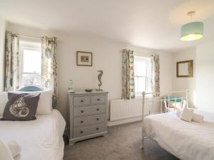 1 Schlafzimmer mit 2 Betten, einer Kommode und 2 Fenstern in der Unterkunft The Ferryman in Weymouth