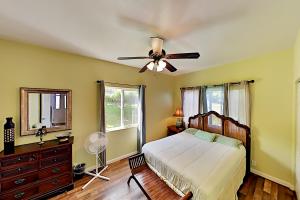 um quarto com uma cama e uma ventoinha de tecto em Big Island Getaway, Ocean View Paradise em Ninole