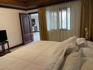 1 dormitorio con 1 cama grande y TV en Hostal Campos Verdes Centro, en Roldanillo