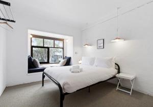 a white bedroom with a bed and a window at Snowgums 10 in Dinner Plain