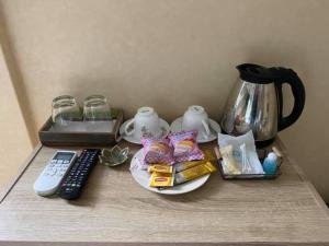 a table with a coffee pot and a remote control at Kurina Hotel in Bangkok