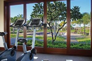 a gym with two exercise bikes in front of a window at Mauna Lani 2002 in Waikoloa