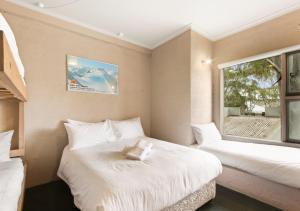a small room with two beds and a window at Snowgums 18 in Dinner Plain