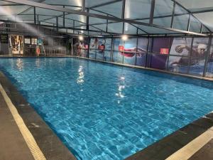 a large swimming pool with blue water in a building at Sanyu Hotel in Guangzhou