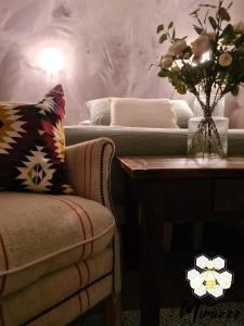a living room with a couch and a table with a vase of flowers at Le Mimizzz in Entraygues-sur-Truyère