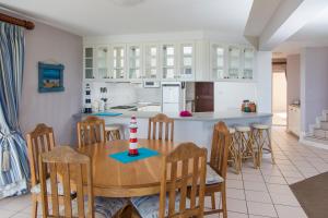 a kitchen and dining room with a wooden table and chairs at Sea View 3 bedrooms Villa in Brenton On The Rocks in Brenton-on-Sea
