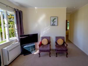 A television and/or entertainment center at Kauri Cottage - Marahau Holiday Home