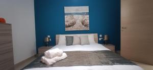 1 dormitorio con 1 cama grande y paredes azules en Searenity, en Marsaxlokk