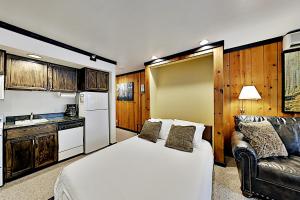 Mountain Village Lodge 221 في بارك سيتي: غرفة نوم بسرير واريكة ومطبخ