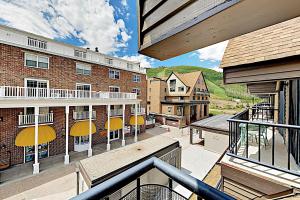 a balcony with tables and yellow umbrellas on a building at Lodge at Mountain Village #306 in Park City