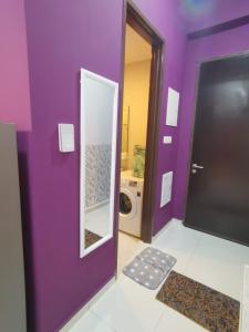 baño púrpura con lavadora y espejo en COUNTRY GARDEN@J Agape Homestay ~ STUDIO COMFORT en Johor Bahru