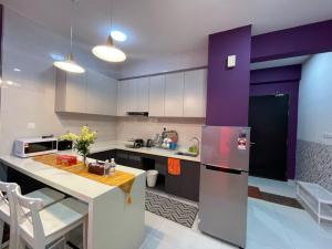 een keuken met paarse en witte kasten en een koelkast bij COUNTRY GARDEN@J Agape Homestay ~ STUDIO COMFORT in Johor Bahru