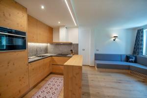 een keuken met een blauwe bank en een tafel in een kamer bij Apartments Alpen Domus in Selva di Val Gardena
