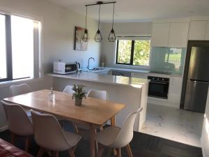 a kitchen with a wooden table and chairs in it at Aroma House in Pokeno